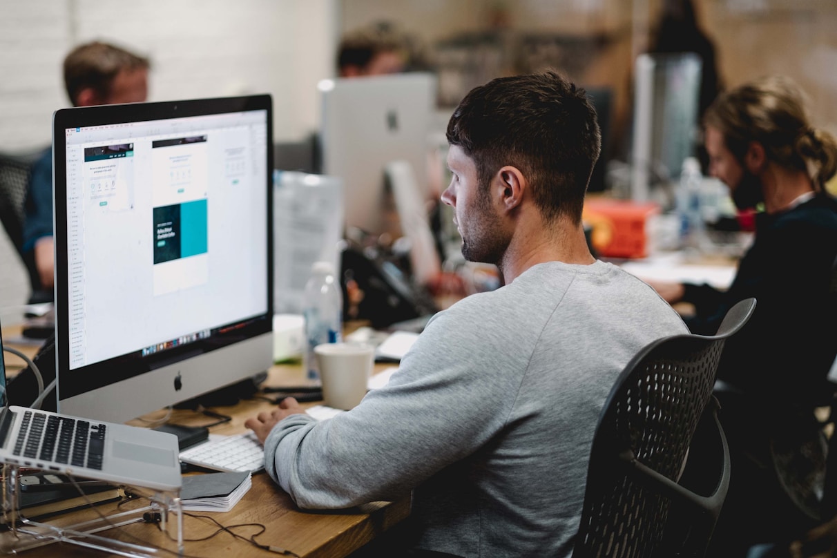 Professional working at a desk with a large monitor